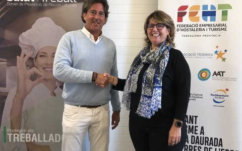 Berta Cabré, presidenta de la FEHT i Paco Lari, director general de Salut i Treball, en un moment de la signatura.