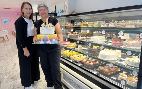 Miriam Albares (esquerra) i Tània Paredes (dreta) al costat de l’aparador on exposen els deliciosos pastissos.